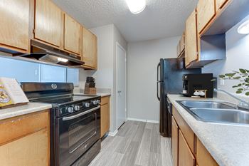 Galley kitchen with black appliances and double sink